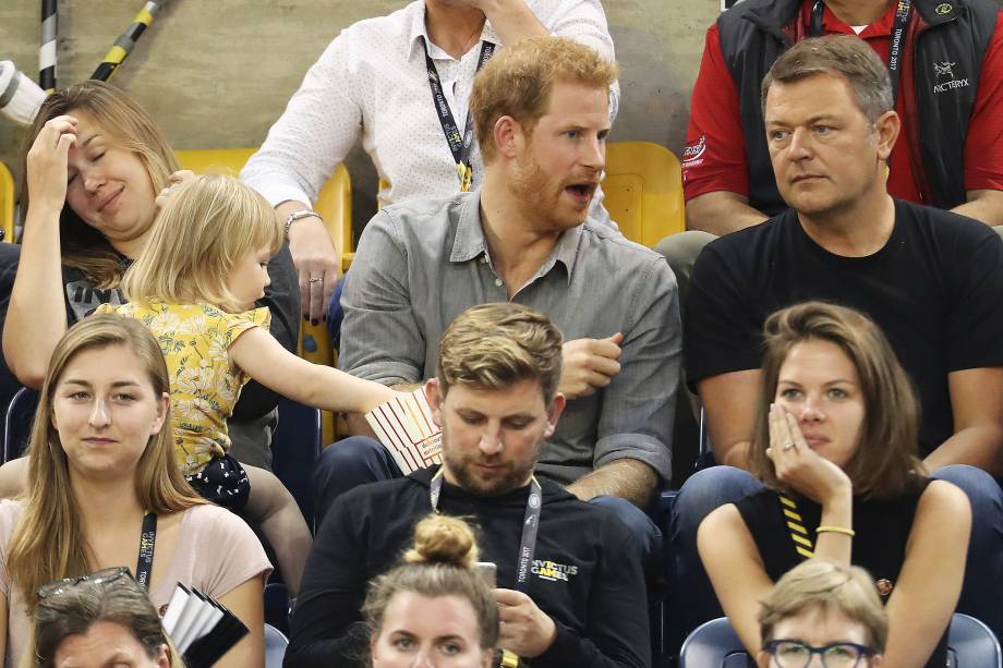 Hayley Henson e a filha Emily Henson sentam-se com o Príncipe Harry para comer pipoca e assistir às finais do vôlei durante os Jogos Invictus 2017 no Centro de Atletismo Mattamy, em Toronto, no Canadá