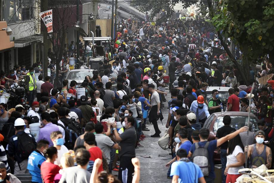 Rescuers, firefighters, policemen, soldiers and volunteers remove rubble and debris from a flattened building in search of survivors after a powerful quake in Mexico City on September 19, 2017.The number of people killed in a devastating earthquake that struck Mexico City and nearby regions on Tuesday has risen to 138, the government said. / AFP PHOTO / PEDRO PARDO