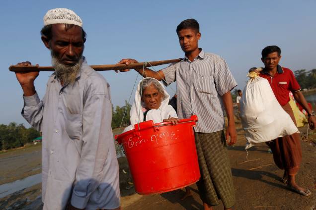 A idosa Boduuzzol Kharun, 97, é carregada por membros da sua família depois de atravessar a fronteira Bangladesh-Mianmar, em Teknaf, Bangladesh - 25/10/2017 A idosa Boduuzzol Kharun, 97, é carregada por membros da sua família depois de atravessar a fronteira Bangladesh-Mianmar, em Teknaf, Bangladesh - 25/10/2017