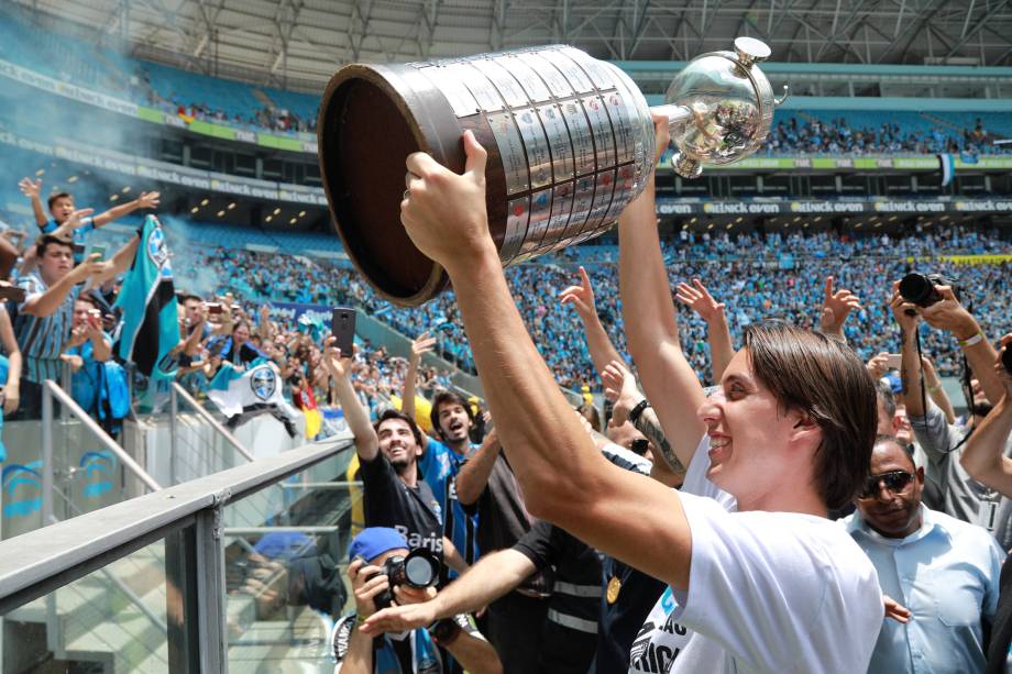 Pedro Geromel ergue a taça da Libertadores durante comemoração com a torcida na Arena do Grêmio em Porto Alegre - 30/11/2017