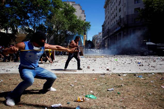 Manifestantes atiram pedras com estilingues durante protesto contra as reformas da previdência social em Buenos Aires, na Argentina Manifestantes atiram pedras com estilingues durante protesto contra as reformas da previdência social em Buenos Aires, na Argentina