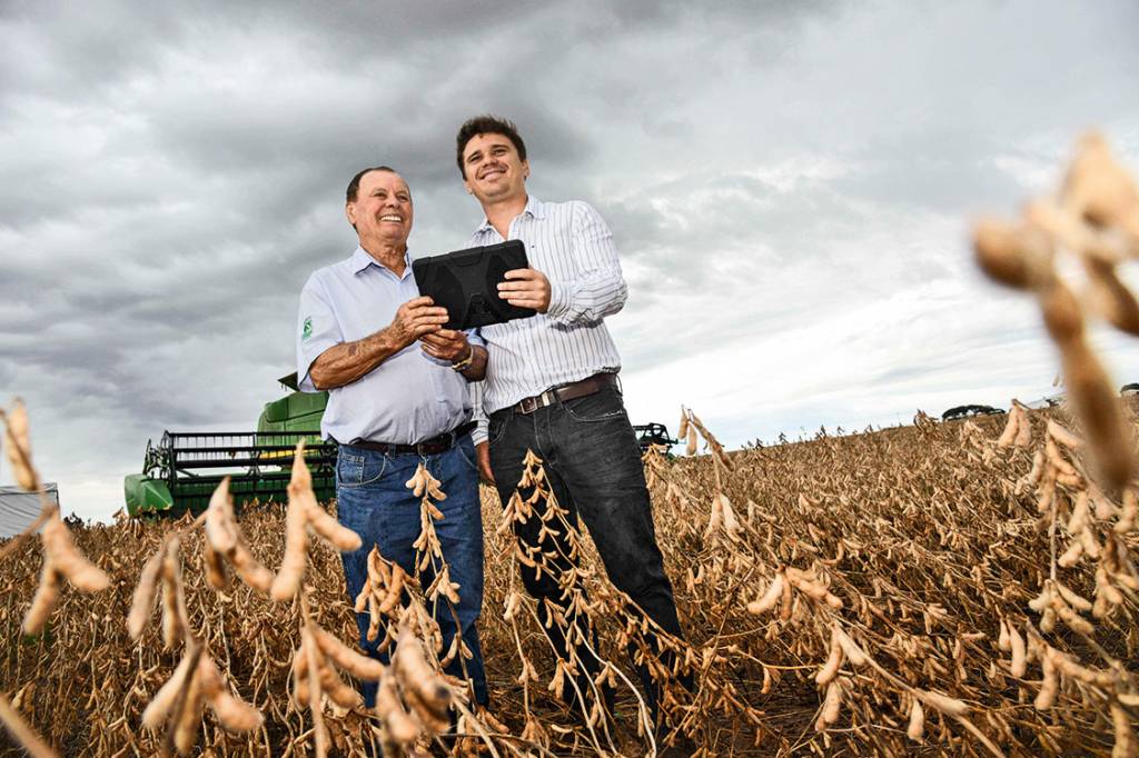 Conectados – Fernando Orlando e seu avô Vilmo Antonio (à esq.), produtores de soja no município de Montividiu, em Goiás: o desempenho da lavoura é acompanhado hora a hora pelo tablet