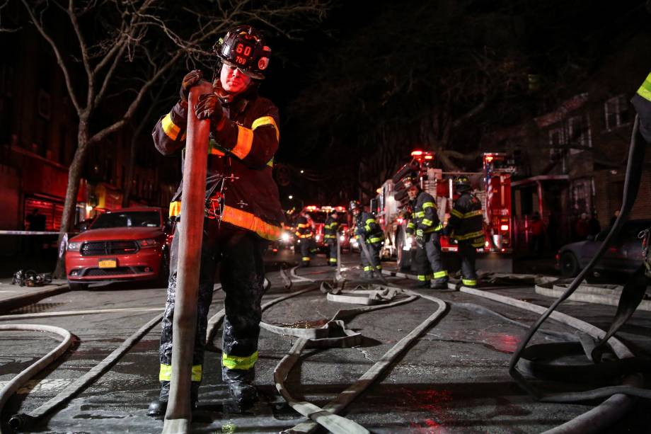 Bombeiros trabalham para controlar um incêndio e resgatar as vítimas em um edifício de apartamentos no bairro do Bronx, em Nova York - 28/12/2017