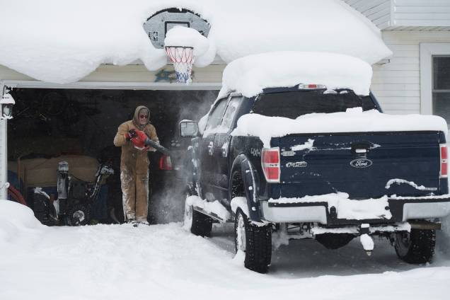 Um homem utiliza o soprador para retirar a neve de cima da sua caminhonete, em Erie, na Pensilvânia - 27/12/2017 Um homem utiliza o soprador para retirar a neve de cima da sua caminhonete, em Erie, na Pensilvânia - 27/12/2017