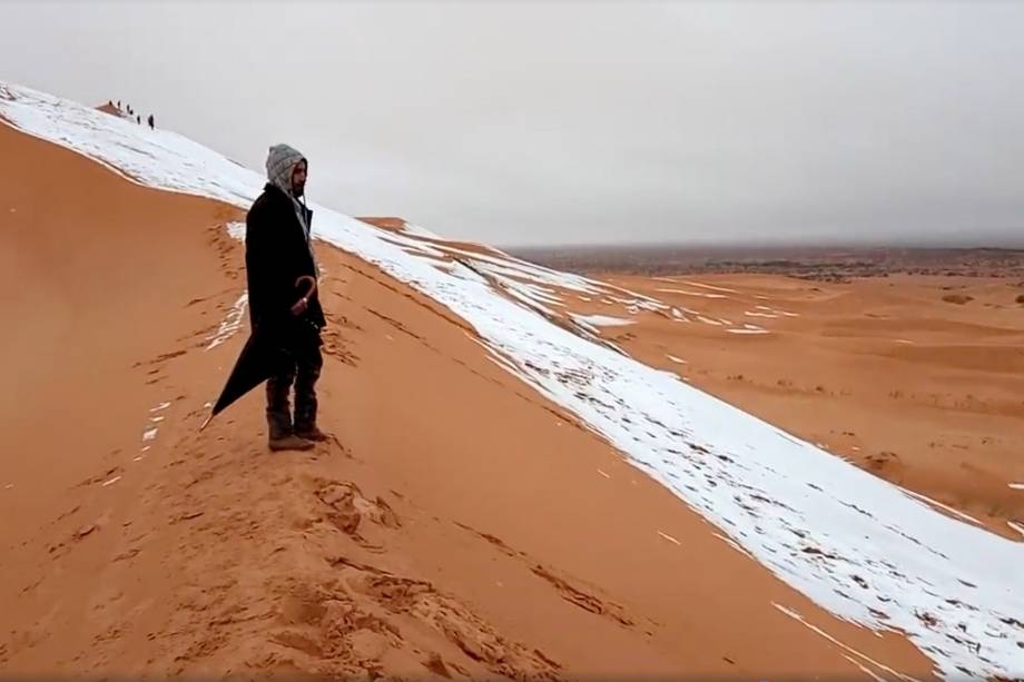 Homem olha para uma duna de areia coberta de neve no Deserto do Saara, em Ain Sefra, na Argélia - 07/01/2018 Homem olha para uma duna de areia coberta de neve no Deserto do Saara, em Ain Sefra, na Argélia - 07/01/2018