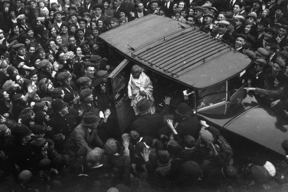 Centenas de pessoas acompanham a chegada de Gandhi a Londres para uma conferência sobre a reforma constitucional da Índia, em 1931