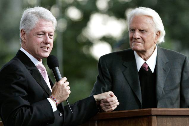 O ex-presidente dos EUA, Bill Clinton, fala junto com Billy Graham durante a cruzada de Graham no Flushing Meadows Corona Park, na cidade de Queens, em Nova York - 25/06/2005 O ex-presidente dos EUA, Bill Clinton, fala junto com Billy Graham durante a cruzada de Graham no Flushing Meadows Corona Park, na cidade de Queens, em Nova York - 25/06/2005
