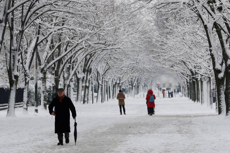 Pessoas andam em um caminho coberto de neve no Champ de Mars em Paris - 07/02/2018