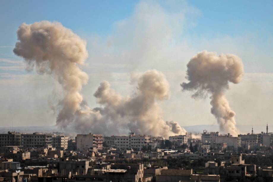 Fumaça sobe dos edifícios após o bombardeio na aldeia de Mesraba, na região de Ghouta ocupada por rebeldes e sitiada nos subúrbios da capital Damasco - 19/02/2018