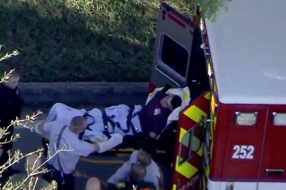 Homem algemado pela polícia é carregado em um veículo paramédico após abrir fogo contra estudantes e professores na Marjory Stoneman Douglas High School em Parkland, Flórida - 14/02/2018