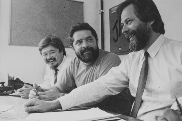 Luiz Gushiken, presidente do Sindicato dos Bancários de São Paulo, Luiz Inácio Lula da Silva, presidente do PT, e José Dirceu, secretário-geral do PT-SP, em 1984. Luiz Gushiken, presidente do Sindicato dos Bancários de São Paulo, Luiz Inácio Lula da Silva, presidente do PT, e José Dirceu, secretário-geral do PT-SP, em 1984.