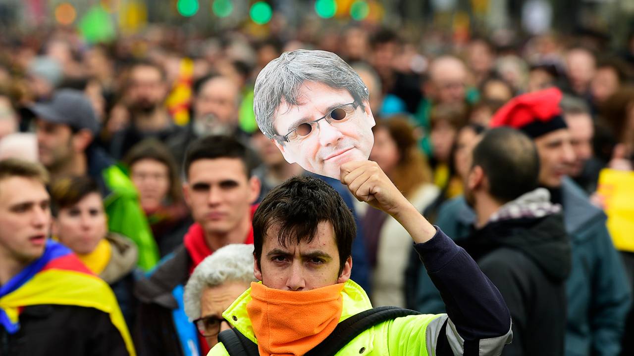 Manifestante segura máscara do ex-presidente da Catalunha, Carles Puigdemont, durante protesto contra sua detenção, em Barcelona - 25/03/2018
