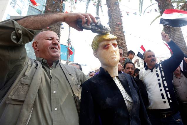 Um palestino coloca um sapato em um manequim representando o presidente dos EUA, Donald Trump, durante um protesto contra os ataques aéreos liderados pelos EUA em Damasco, em Nablus, na Cisjordânia ocupada - 14/04/2018 Um palestino coloca um sapato em um manequim representando o presidente dos EUA, Donald Trump, durante um protesto contra os ataques aéreos liderados pelos EUA em Damasco, em Nablus, na Cisjordânia ocupada - 14/04/2018