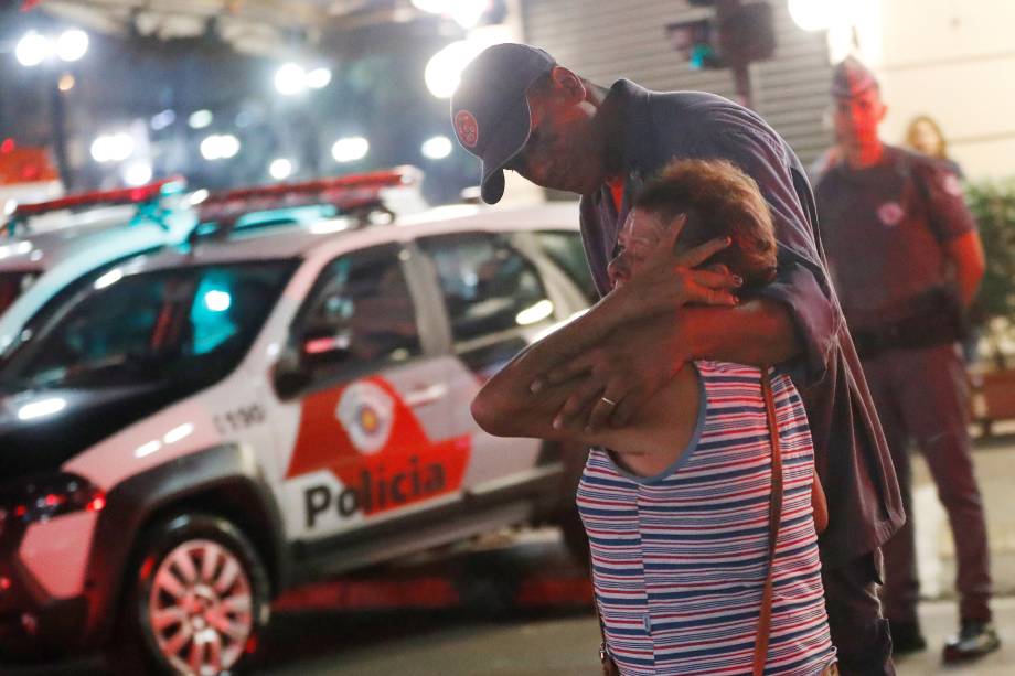 Bombeiro tenta confortar uma mulher durante incêndio em um edifício ocupado por moradores sem-teto no Largo do Paissandu, no centro de São Paulo - 01/05/2018