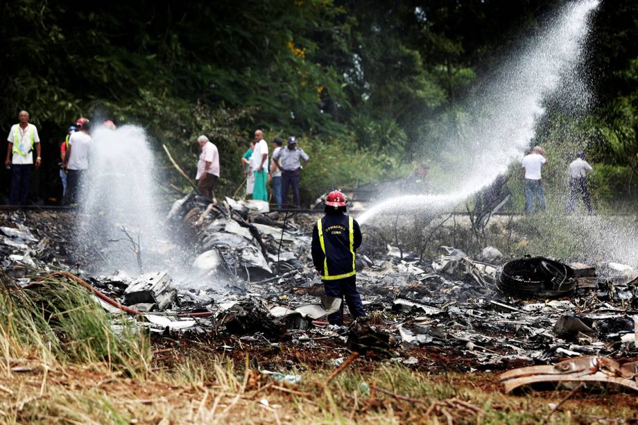 Bombeiro realiza trabalho de rescaldo após avião cair depois de decolar em Havana  - 18/05/2018