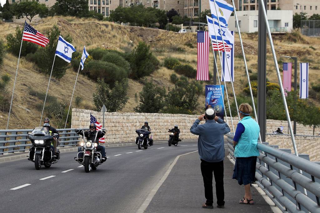 Inauguração da embaixada americana em Jerusalém Pedestres observam passagem de motociclistas nas ruas de Jerusalém com bandeiras, antes da Inauguração da embaixada americana - 13/05/2018