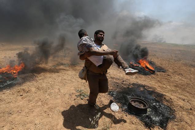 Manifestantes ferido é carregado durante protesto contra a mudança da embaixada americana para Jerusalém e antes do 70º aniversário de Nakba, na fronteira entre Israel e Gaza - 14/05/2018 Manifestantes ferido é carregado durante protesto contra a mudança da embaixada americana para Jerusalém e antes do 70º aniversário de Nakba, na fronteira entre Israel e Gaza - 14/05/2018