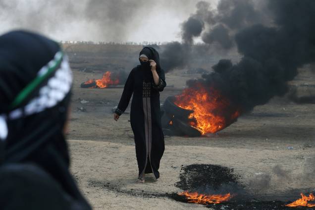 Manifestante palestina caminha durante protesto contra a mudança da embaixada americana para Jerusalém e antes do 70º aniversário de Nakba, no sul da Faixa de Gaza - 14/05/2018 Manifestante palestina caminha durante protesto contra a mudança da embaixada americana para Jerusalém e antes do 70º aniversário de Nakba, no sul da Faixa de Gaza - 14/05/2018