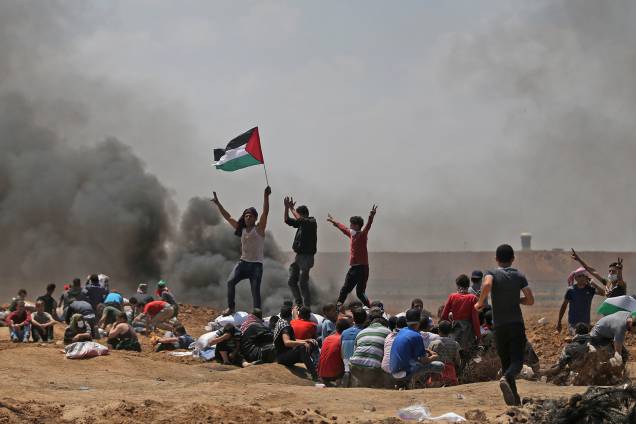 Palestino segura bandeira durante protesto contra inauguração de embaixada do Estados Unidos em Jerusalém - 14/05/2018 Palestino segura bandeira durante protesto contra inauguração de embaixada do Estados Unidos em Jerusalém - 14/05/2018