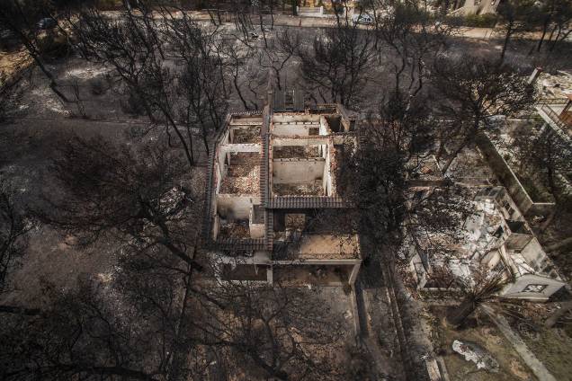 A fotografia aérea mostra a destruição causada por um incêndio florestal nas casas do vilarejo de Mari, na Grécia - 24/07/2018 A fotografia aérea mostra a destruição causada por um incêndio florestal nas casas do vilarejo de Mari, na Grécia - 24/07/2018