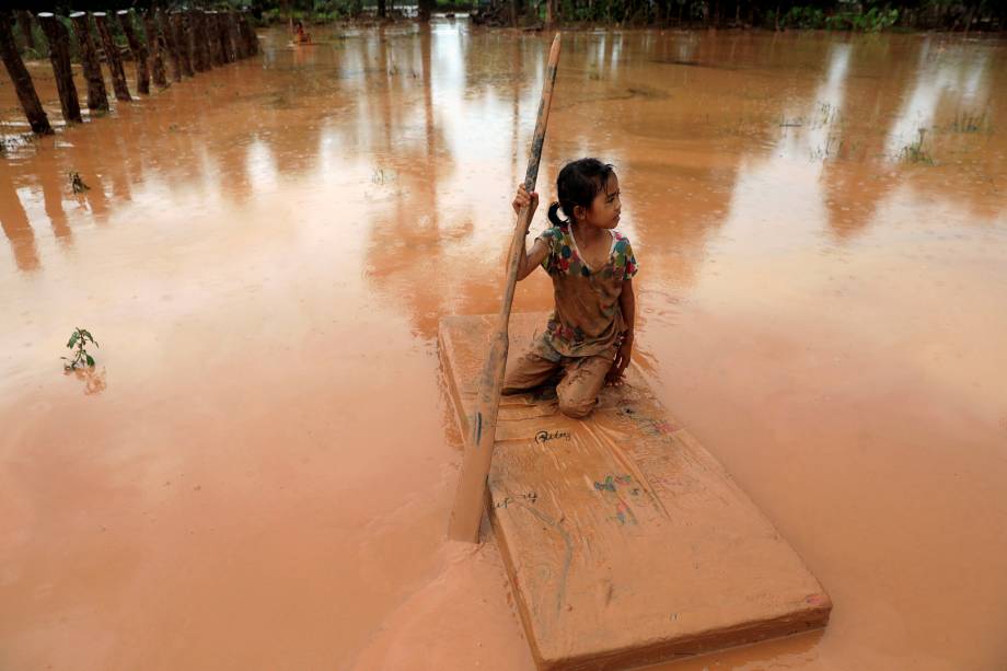 Menina usa um colchão como barco durante uma enchente provocada pelo colapso da represa da usina hidrelétrica Xepian-Xe Namnoy na província de Attapeu, no Laos - 26/07/2018