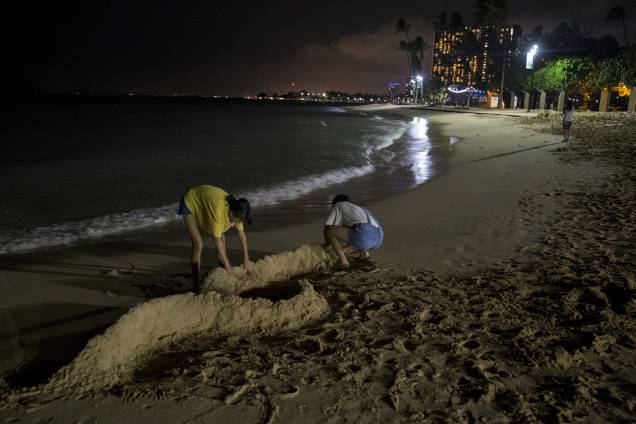 Turistas fazem barreiras com areia, antes da passagem do furacão Lane na praia de Waikiki, em Honolulu, Havaí - 23/08/2018 Turistas fazem barreiras com areia, antes da passagem do furacão Lane na praia de Waikiki, em Honolulu, Havaí - 23/08/2018