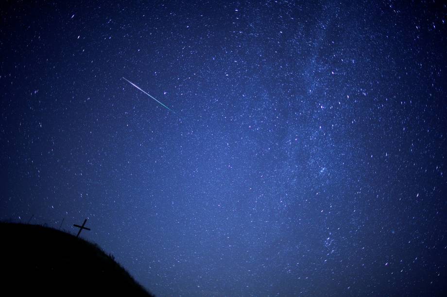 Meteoro risca o céu com a Via Láctea visível acima da colina de Leeberg durante a chuva de meteoros Perseidas em Grossmugl, na Áustria - 12/08/2018