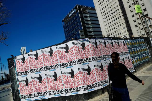 Pedestre caminha próxima de cartazes fixados em muro, durante greve geral em Buenos Aires, capital da Argentina - 25/09/2018 Pedestre caminha próxima de cartazes fixados em muro, durante greve geral em Buenos Aires, capital da Argentina - 25/09/2018