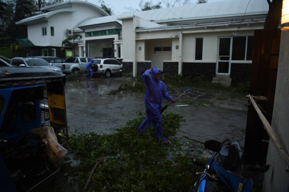 Trabalhadores removem galhos de uma árvore derrubado pelos ventos do supertufão Mangkhut que atingiu a cidade de Tuguegarao, província de Cagayan, ao norte de Manila nas Filipinas - 15/09/2018