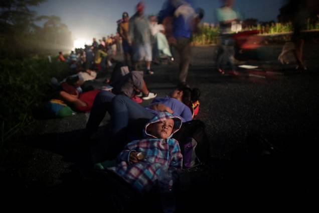 Glenda Escobar, 33, uma imigrante de Honduras deita com seu filho Adonei na beira de uma estrada durante uma caravana de milhares de latino-americanos rumo aos Estados Unidos, em seu caminho para Pijijiapan de Mapastepec, no México - 25/10/2018 Glenda Escobar, 33, uma imigrante de Honduras deita com seu filho Adonei na beira de uma estrada durante uma caravana de milhares de latino-americanos rumo aos Estados Unidos, em seu caminho para Pijijiapan de Mapastepec, no México - 25/10/2018