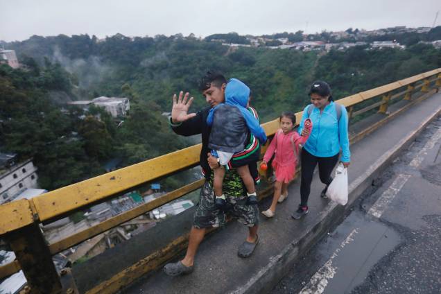 Imigrantes hondurenhos, parte de uma caravana que tenta chegar aos Estados Unidos, caminham em uma ponte durante sua viagem na Cidade da Guatemala, Guatemala - 18/10/2018 Imigrantes hondurenhos, parte de uma caravana que tenta chegar aos Estados Unidos, caminham em uma ponte durante sua viagem na Cidade da Guatemala, Guatemala - 18/10/2018