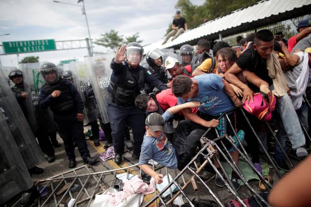 Policiais tentam conter um enorme grupo de imigrantes hondurenhos que tentavam atravessar a fronteira da Guatemala para entrar no México, em Ciudad Hidalgo - 20/10/2018 Policiais tentam conter um enorme grupo de imigrantes hondurenhos que tentavam atravessar a fronteira da Guatemala para entrar no México, em Ciudad Hidalgo - 20/10/2018