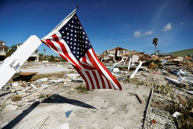 Bandeira dos Estados Unidos é vista próxima de casas destruídas após a passagem do furacão Michael em Mexico Beach, Flórida - 11/10/2018 Bandeira dos Estados Unidos é vista próxima de casas destruídas após a passagem do furacão Michael em Mexico Beach, Flórida - 11/10/2018