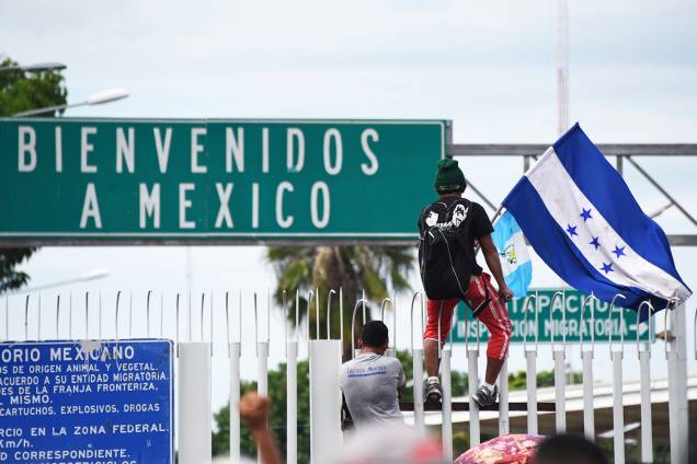 Migrante hondurenho é visto com bandeira, próximo da fronteira entre a Guatemala e o México, no território de Ciudad Tecun Uman - 19/10/2018 Migrante hondurenho é visto com bandeira, próximo da fronteira entre a Guatemala e o México, no território de Ciudad Tecun Uman - 19/10/2018