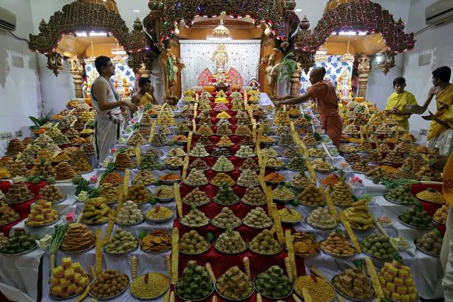Sacerdote organiza doces guardados dentro de um templo como oferendas de devotos hindus para um ritual que marca o festival "Annakut" durante o Diwali, o festival hindu das luzes, em Ahmedabad, na Índia - 07/11/2018 Sacerdote organiza doces guardados dentro de um templo como oferendas de devotos hindus para um ritual que marca o festival "Annakut" durante o Diwali, o festival hindu das luzes, em Ahmedabad, na Índia - 07/11/2018
