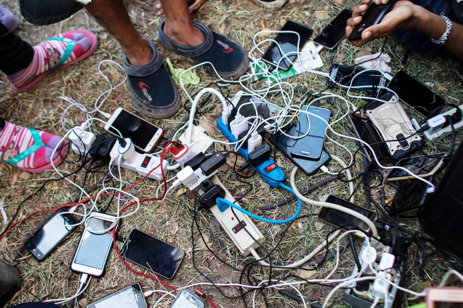 Imigrantes da América Central carregam seu celulares na cidade mexicana de Juchitán de Zaragoza, durante caravana rumo aos Estados Unidos - 30/10/2018