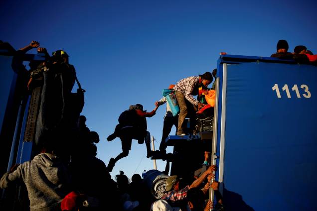 Imigrantes da caravana de milhares de pessoas da América Central que tentam chegar aos Estados Unidos, viajam sobre um caminhão enquanto se dirigem a Tijuana de Mexicali, no México - 20/11/2018 Imigrantes da caravana de milhares de pessoas da América Central que tentam chegar aos Estados Unidos, viajam sobre um caminhão enquanto se dirigem a Tijuana de Mexicali, no México - 20/11/2018
