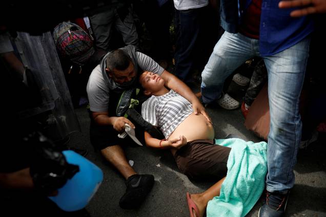 Imigrante grávida, parte da caravana de El Salvador que tenta entrar nos Estados Unidos desmaia durante uma operação da polícia mexicana para detê-los por entrar ilegalmente no país, em Metapa - 21/11/2018 Imigrante grávida, parte da caravana de El Salvador que tenta entrar nos Estados Unidos desmaia durante uma operação da polícia mexicana para detê-los por entrar ilegalmente no país, em Metapa - 21/11/2018
