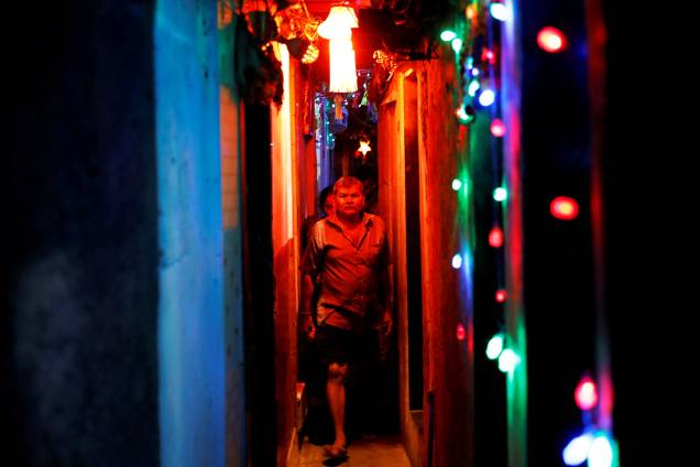 Moradores caminham em beco de uma favela iluminado por luzes coloridas às vésperas do festival hindu Diwali em Mumbai, na Índia - 06/11/2018 Moradores caminham em beco de uma favela iluminado por luzes coloridas às vésperas do festival hindu Diwali em Mumbai, na Índia - 06/11/2018
