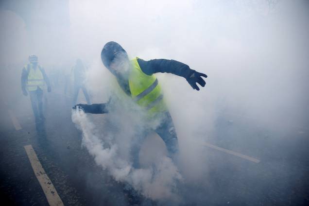 Manifestante é visto com uma bomba de gás lacrimogêneo durante a manifestação contra a alta dos impostos sobre o diesel - 01/12/2018 Manifestante é visto com uma bomba de gás lacrimogêneo durante a manifestação contra a alta dos impostos sobre o diesel - 01/12/2018