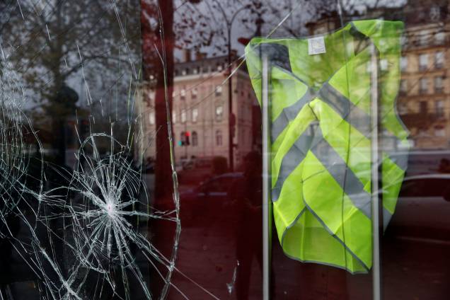 Um colete amarelo é visto dentro de uma loja vandalizada na manhã seguinte dos confrontos entre manifestantes vestindo coletes amarelos, um símbolo de um protesto de motoristas franceses contra os impostos mais altos sobre o diesel, e forças policiais em Paris, na França - 02/12/2018 Um colete amarelo é visto dentro de uma loja vandalizada na manhã seguinte dos confrontos entre manifestantes vestindo coletes amarelos, um símbolo de um protesto de motoristas franceses contra os impostos mais altos sobre o diesel, e forças policiais em Paris, na França - 02/12/2018