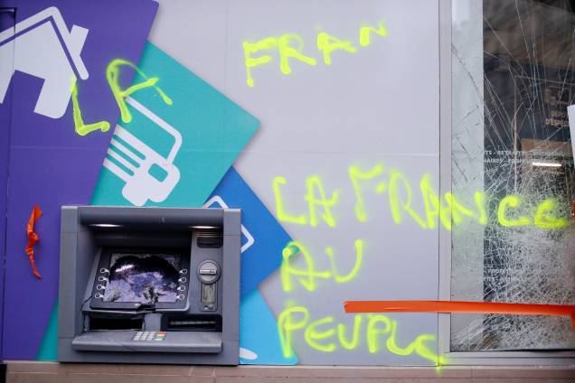 Uma pixação é vista ao lado de um caixa eletrônico depredado no dia seguinte das manifestações em Paris - 02/12/2017 Uma pixação é vista ao lado de um caixa eletrônico depredado no dia seguinte das manifestações em Paris - 02/12/2017