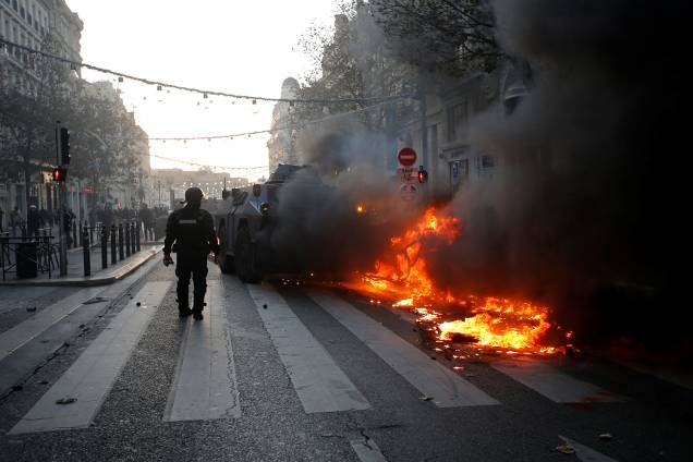 Guarda francês observa carro incendiado durante protesto em Marseille, França - 08/12/2018 Guarda francês observa carro incendiado durante protesto em Marseille, França - 08/12/2018
