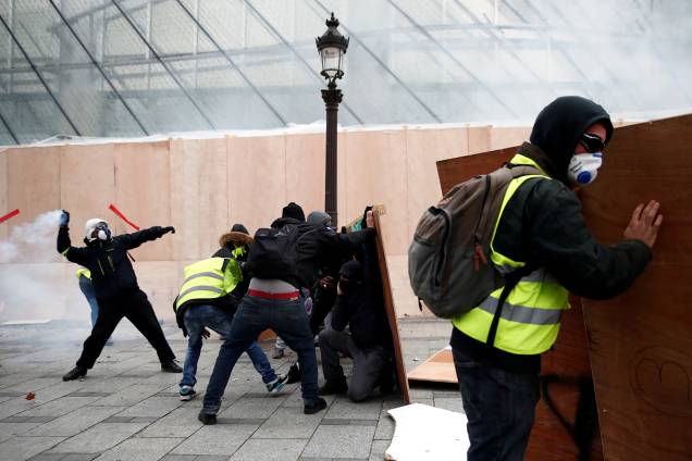 Manifestantes vestindo coletes amarelos entram em confronto com a Polícia na Avenida Champs-Élysées em Paris, França - 08/12/2018 Manifestantes vestindo coletes amarelos entram em confronto com a Polícia na Avenida Champs-Élysées em Paris, França - 08/12/2018
