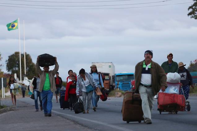 Pessoas carregam malas durante a travessia da Venezuela para o Brasil, em Pacaraima, no estado de Roraima - 22/02/2019 Pessoas carregam malas durante a travessia da Venezuela para o Brasil, em Pacaraima, no estado de Roraima - 22/02/2019