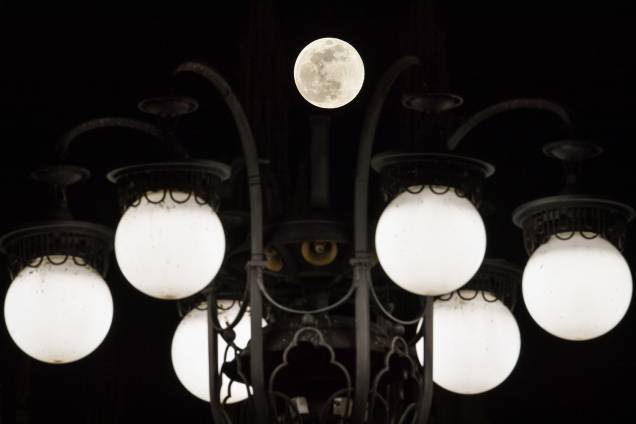 Superlua é fotografada entre luzes na Piazza del Duomo - praça localizada em Milão, na Itália - 19/02/2019 Superlua é fotografada entre luzes na Piazza del Duomo - praça localizada em Milão, na Itália - 19/02/2019