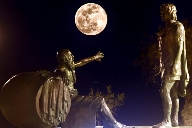 Superlua é vista entre as estátuas de Alexandre, o Grande (dir) e Diógenes de Sinope (esq), na cidade de Corinto, localizada a 83 quilômetros de Atenas, na Grécia - 19/02/2019 Superlua é vista entre as estátuas de Alexandre, o Grande (dir) e Diógenes de Sinope (esq), na cidade de Corinto, localizada a 83 quilômetros de Atenas, na Grécia - 19/02/2019