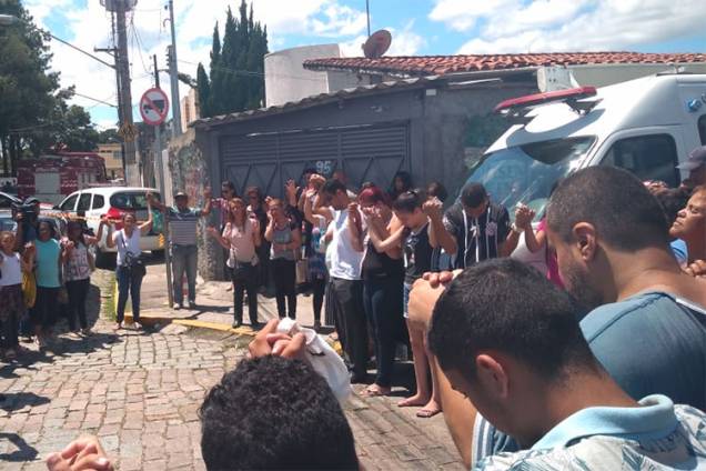 Familiares, alunos e vizinhos fazem oração em frente à Escola Estadual Raul Brasil, horas depois do ataque Familiares, alunos e vizinhos fazem oração em frente à Escola Estadual Raul Brasil, horas depois do ataque