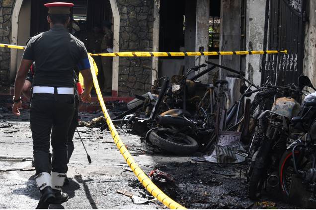 Policial passa ao lado de motocicletas destruídas do lado de fora da Igreja Zion, após uma explosão em Batticaloa, no leste do Sri Lanka - 21/04/2019 Policial passa ao lado de motocicletas destruídas do lado de fora da Igreja Zion, após uma explosão em Batticaloa, no leste do Sri Lanka - 21/04/2019