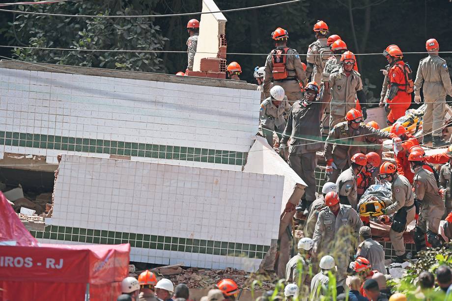 Equipe de resgate carregam vítima de desabamento de prédio na comunidade de Muzema, no Rio de Janeiro - 12/04/2019